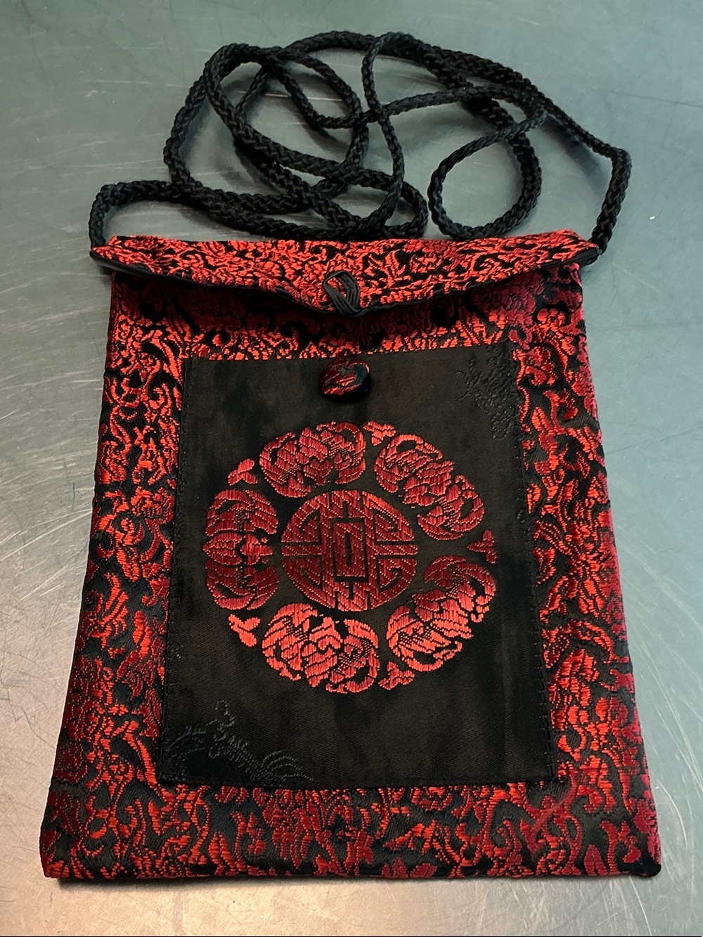Asian inspired envelope style fabric crossbody pouch.